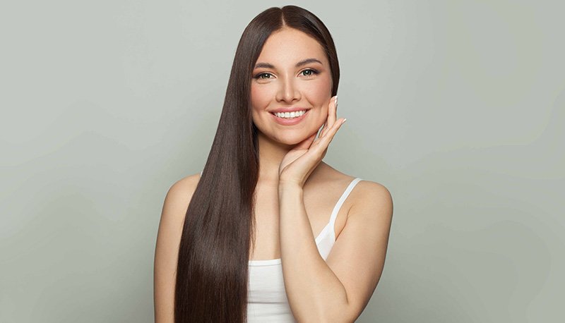 uśmiechnięta kobieta o długich, gładkich, nawilżonych włosach